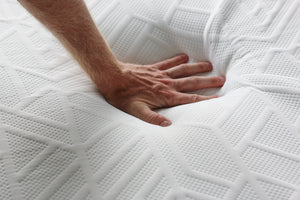 close up of mlily wellflex mattress with hand on it